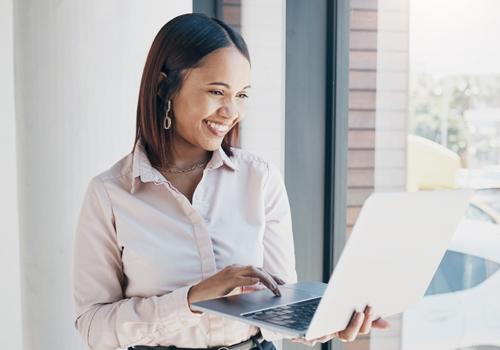 Smiling woman holding laptop at Resident Choice Awards event - Opiniion: Resident Insight that Drives Property Success